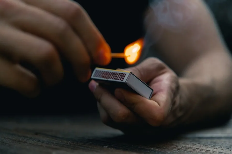 A person lighting a match